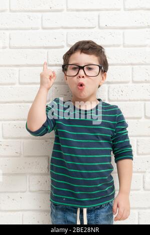 Little Boy in glasses raised his index finger up. Idea came to mind Stock Photo