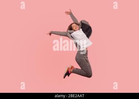 Portrait of overjoyed enthusiastic ecstatic businesswoman in elegant suit jumping carefree in air, flying from happiness, inspired by success, freedom Stock Photo