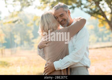 Happy senior couple hugging in park  in love and romantic Stock Photo
