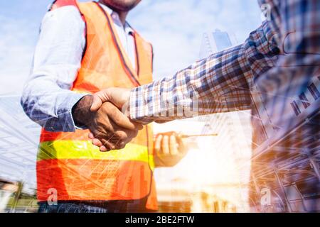 Architect contractor shaking hands with client at construction site Stock Photo