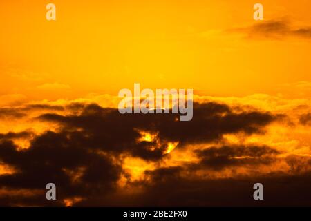 Beautiful sunset with the clouds covering the sun. Very big sun. Stock Photo