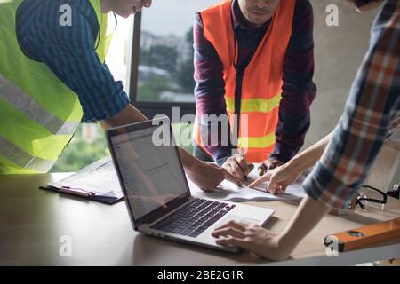 team of engineer planing and working with laptop and blue print on working table in construction site Stock Photo