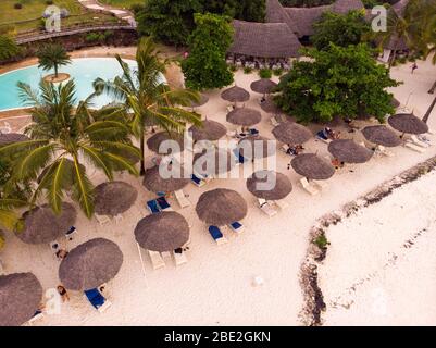 Aerial view of Thatched roofed beach umbrellas of luxury ocean view resort at the beautiful white sand ocean coast in Nungwi at Zanzibar island Stock Photo