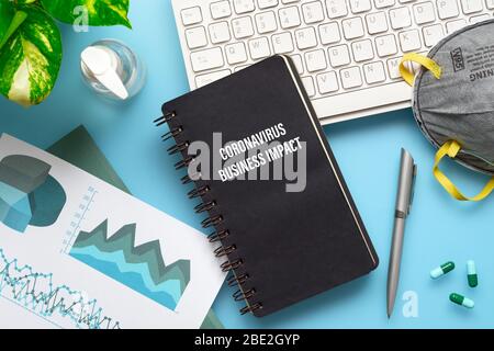COVID-19 or Corona virus Business IMPACT background concept. Mockup Notebook for Covid 19 business impact anlysis with busines graphs sheets, N95 faci Stock Photo