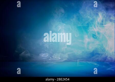 dark blue cement wall studio background with mist or fog, colorful smoke backdrop Stock Photo