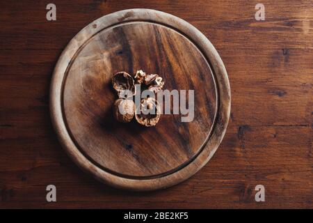 Top view of walnuts on rustic wooden plate Stock Photo