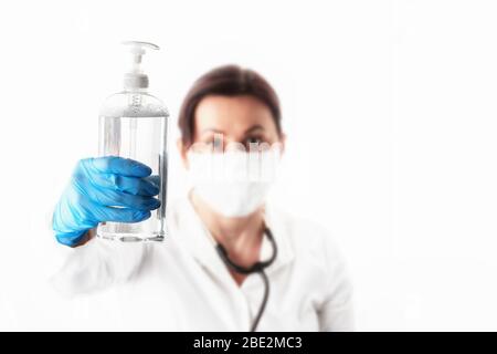 Young Woman in Medical Protective Mask and Gloves Showing Sanitizer. Prevention and Stop  infection concept. Stock Photo