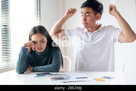 Angry boy friend alright girl friend about  payment for shopping online, Young Asian couple felling stress, serious about financial problem of credit Stock Photo