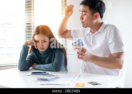 Angry boy friend alright girl friend about  payment for shopping online, Young Asian couple felling stress, serious about financial problem of credit Stock Photo