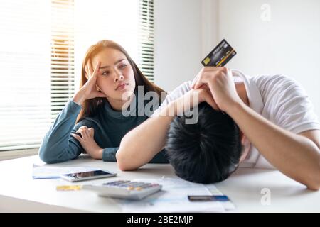 Young Asian couple felling stress, serious about financial problem of credit card debt and loan bill from shopping online Stock Photo