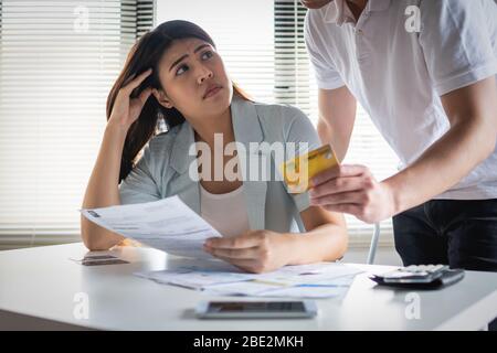 Angry boy friend alright girl friend about  payment for shopping online, Young Asian couple felling stress, serious about financial problem of credit Stock Photo