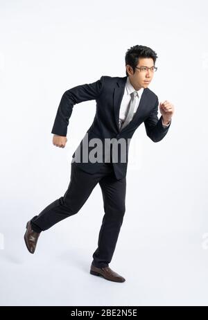 Confidential businessman in formal suit running isolated on white background in studio, determined and full power concept Stock Photo