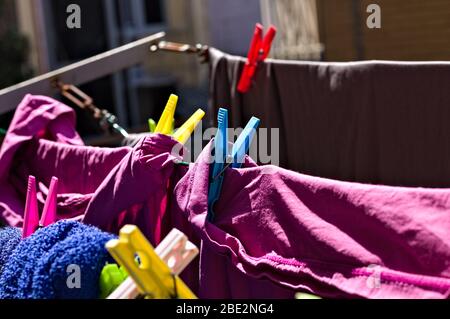 Colored towels and bed sheets hanging on a drying rack with colored clothespins (Pesaro, Italy, Europe) Stock Photo
