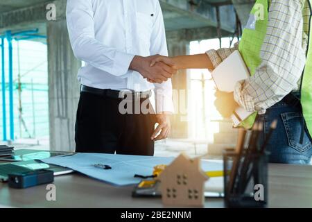 Close up engineer shaking  hand with business man in construction site , successful negotiate of manager and industrial agreement cooperation concept Stock Photo