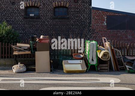 Unwanted furniture and household stuffs outside the brick house on the street of countryside in Germany. Stock Photo
