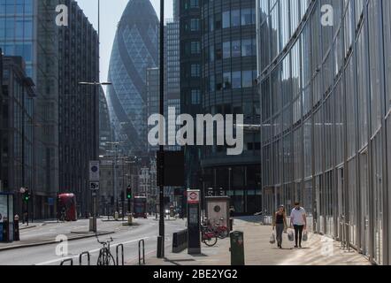 London, UK. 11th Apr, 2020. A couple walks with shopping bags near by Liverpool Street Station. Members of the society were ordered to stay at home and limit social contacts. Only essential travel is allowed due to the outbreak of coronavirus. Credit: Marcin Nowak/Alamy Live News