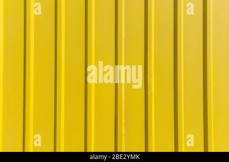 Yellow metal sheet panel or cladding with vertical line wave pattern. Stock Photo