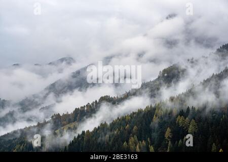 Mystic cloudy and foggy autumn alpine mountain slopes scene. Austrian Lienzer Dolomiten Alps. Peaceful picturesque traveling, seasonal, nature and cou Stock Photo
