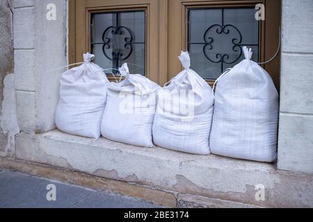 Sandbags stacked in front of doors to protect against flooding of water. Stock Photo