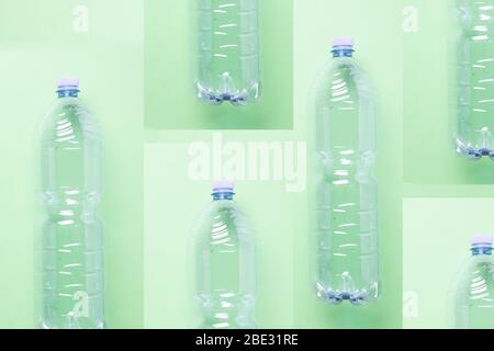 an artsy minimalistic compostion of empty plastic bottles against a pastel light green background, flat lay, studio shot Stock Photo