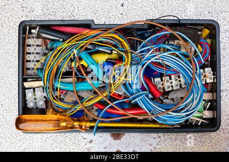 Small electricians tools and bits box. Screwdrivers, snips, wire, connector blocks Stock Photo