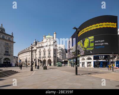 Government messages on led screen at an empty, deserted Piccadilly Circus during enforced lockdown in London due to coronavirus covid 19 flu pandemic Stock Photo
