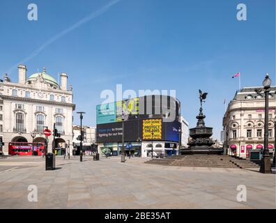 Government messages on led screen at an empty, deserted Piccadilly Circus during enforced lockdown in London due to coronavirus covid 19 flu pandemic Stock Photo