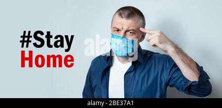 Man Warning To Stay At Home Posing Over Gray Background Stock Photo