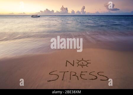 Handwritten No Stress on sandy beach at sunset,relax and summer concept,Dominican republic beach. Stock Photo