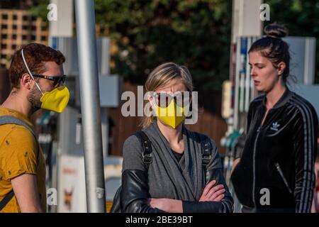 London, UK. 11th Apr, 2020. A couple in matching masks head to the mini Sainsburys at the petrol station - The 'lockdown' continues for the Coronavirus (Covid 19) outbreak in London. Credit: Guy Bell/Alamy Live News