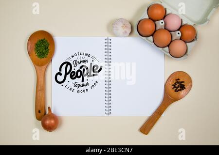 Wooden spoons with spices, eggs and garlic with a blank notebook page Stock Photo