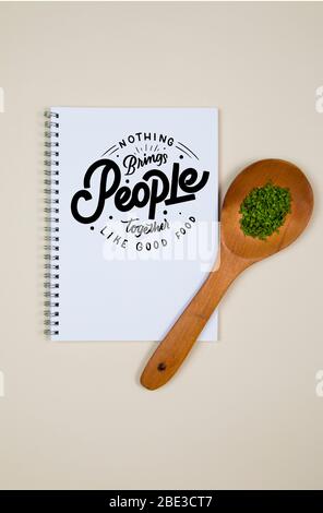 Wooden ladle with some herb spice and a blank notebook page Stock Photo