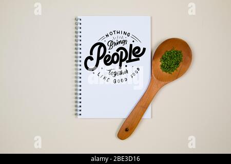 Wooden ladle with some herb spice and a blank notebook page Stock Photo