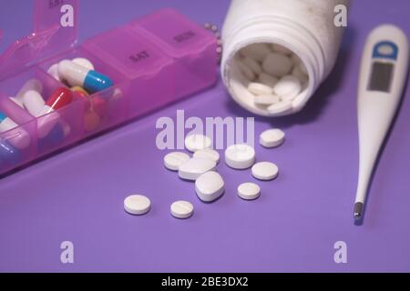colorful pills spilling from container on color background  Stock Photo
