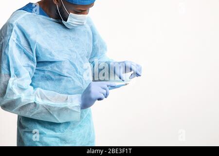 Concentrated black surgeon holding scalpel isolated on white background Stock Photo