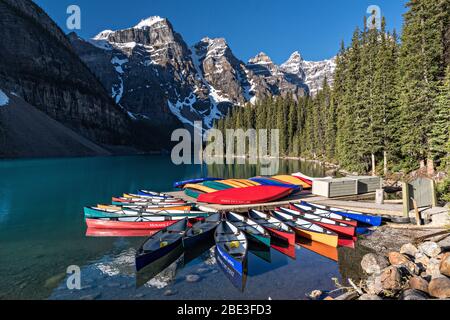 Colorful canoes docked in the turquoise waters of Lake Louise and the snow dusted Fairview Mountain behind in Banff National Park in Alberta, Canada. Stock Photo