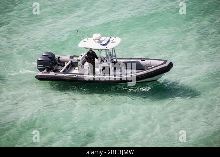 A Florida Wildlife Commission Law Enforcement Officer patrols along a closed beach during the COVID-19 pandemic Stock Photo