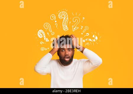 Shocked black guy with question mark over his head Stock Photo