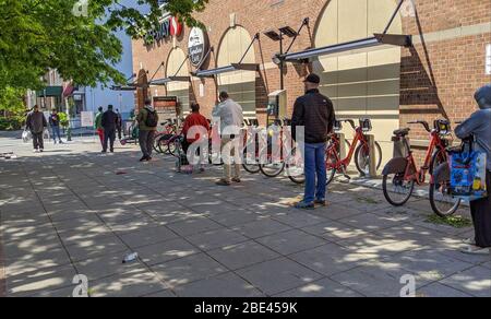 Shoppers practice social distancing waiting to enter a Safeway grocery store in Washington DC. Stock Photo