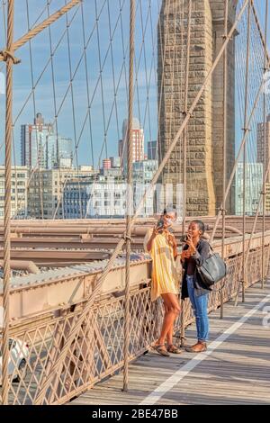 Tourists sightseeing and taking selfies at the Brooklyn Bridge in New York Stock Photo