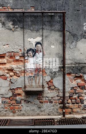 Children on a swing, artwork from Louis Gan in Penang, Malaysia - Niños en un columpio, obra de arte de Louis Gan en Penang, Malasia Stock Photo