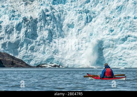 Kayaker in front of a tidewater glacier in Prince William Sound; Alaska, United States of America Stock Photo