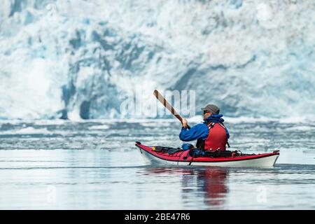 Kayaker in front of a tidewater glacier in Prince William Sound; Alaska, United States of America Stock Photo