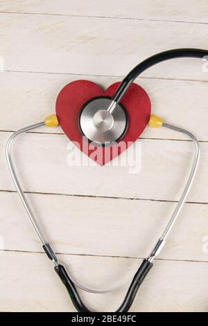 Heart with stethoscope on white wooden table. Medical concept. Top views with clear space Stock Photo