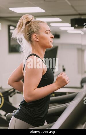 Woman working out on a treadmill; Wellington, New Zealand Stock Photo