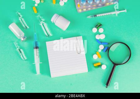 Pharmaceutical research and clinical trials concept. Medicine vial bottle for injection with vaccine and new pharmacy drug in pills and white paper Stock Photo