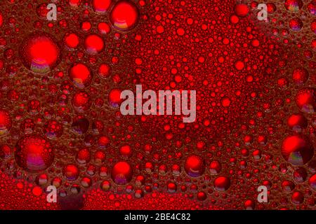 Abstract Background of Oil Bubbles on Water Surface.  red background with oil circles close up Stock Photo