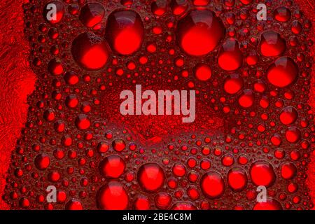 Abstract Background of Oil Bubbles on Water Surface.  red background with oil circles Stock Photo