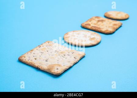 Crackers on blue background in perspective with shallow focus Stock Photo