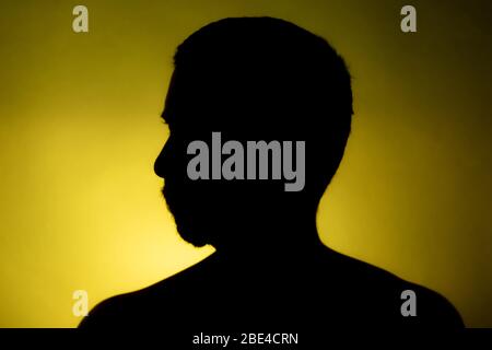 Cleanly defined silhouette of a male person turned to the left against a  blue background with